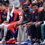 New Orleans Pelicans forward Brandon Ingram, guard CJ McCollum, guard Dejounte Murray, forward Zion Williamson, center Yves Missi, and forward Herbert Jones watch from the bench